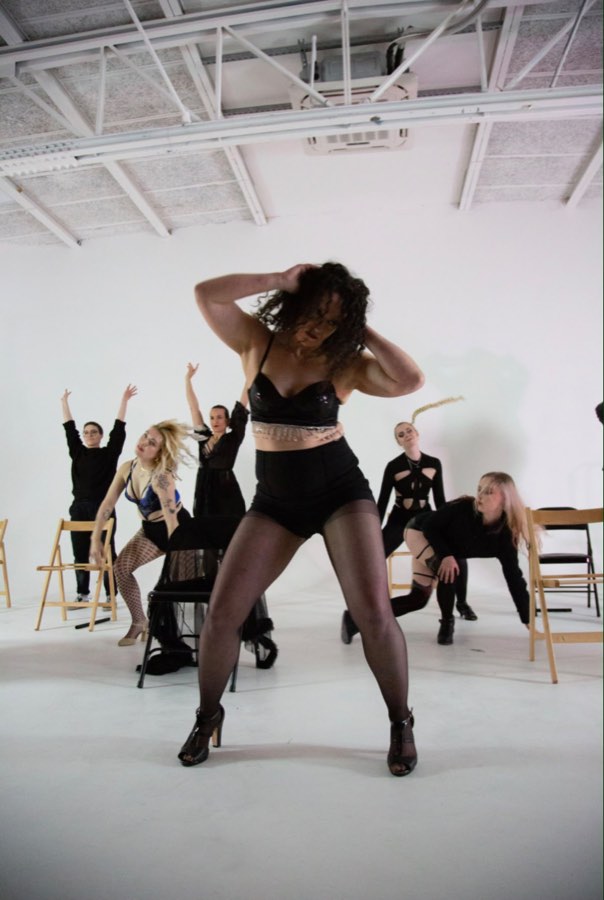 Burlesque class practising a chair routine together in the studio