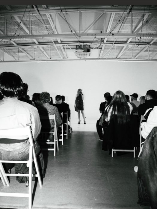 Burlesque performer on stage in front of an audience at a showcase