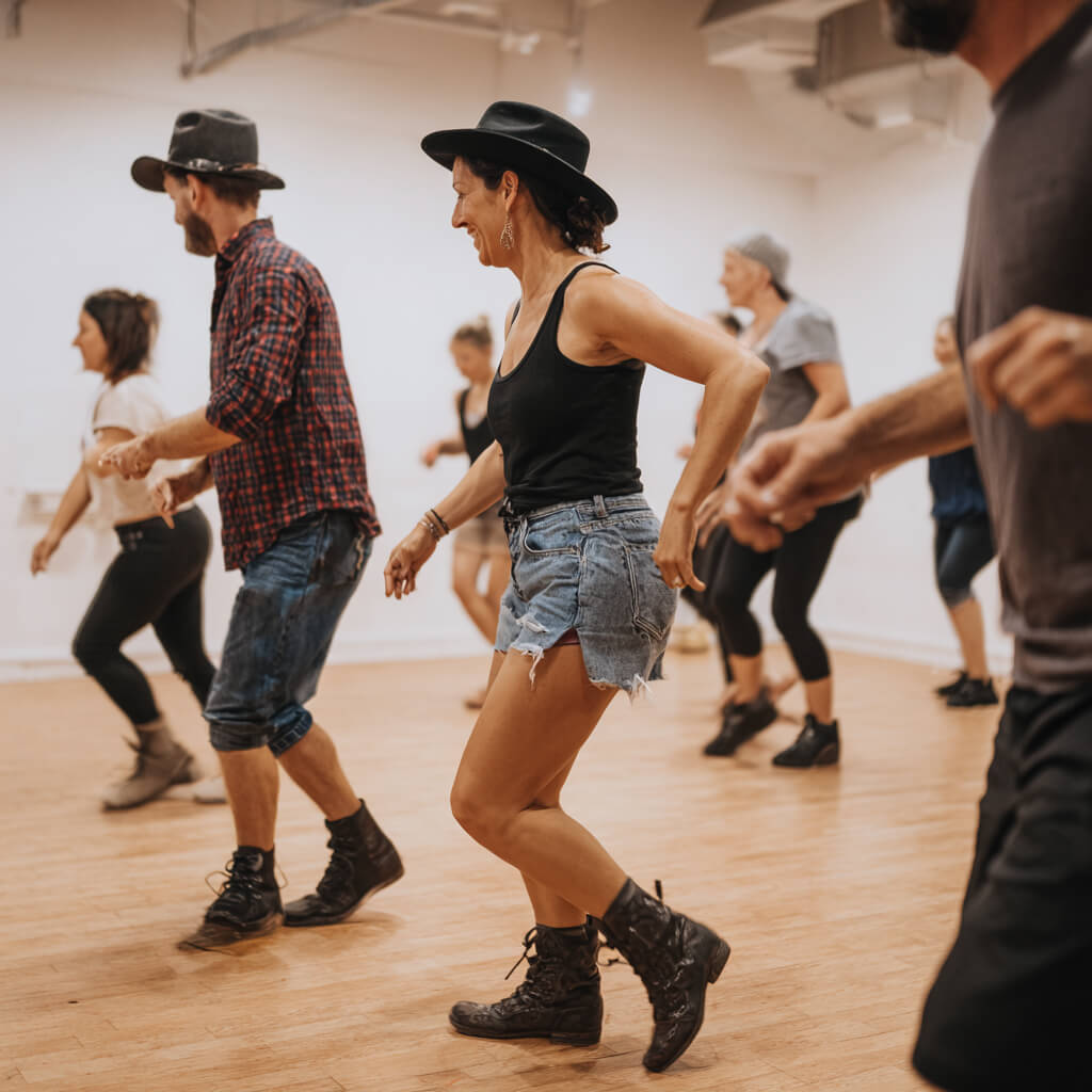 Group enjoying line dancing hen party with country moves and boot scootin' choreography