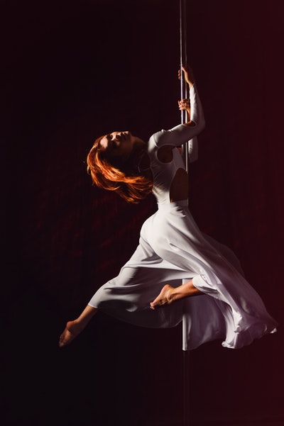 Adult pole dancing class - beginners learning pole fitness and strength training